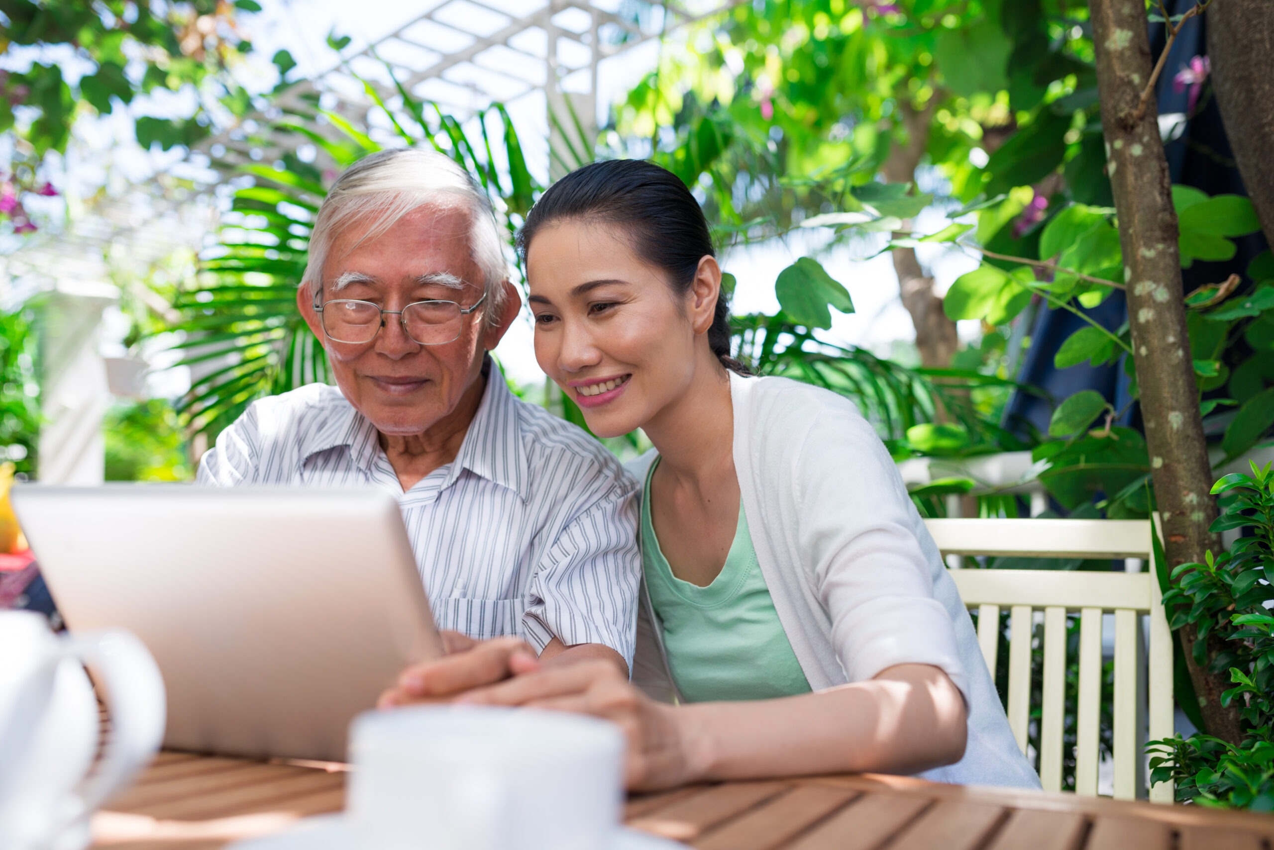 elderly man and his daughter looking at a laptop