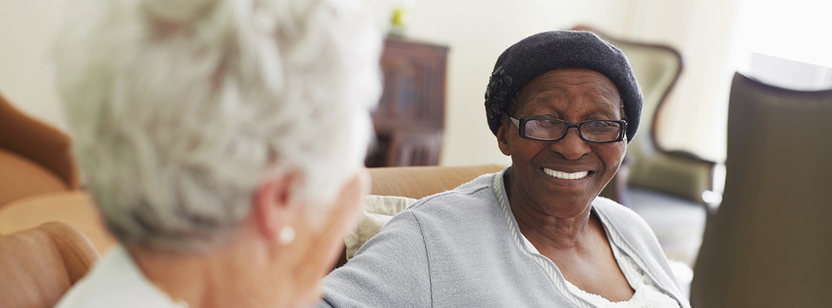 two elderly women sitting and laughing together