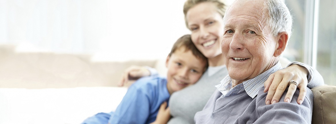 elderly resident sitting with his daughter and grandson