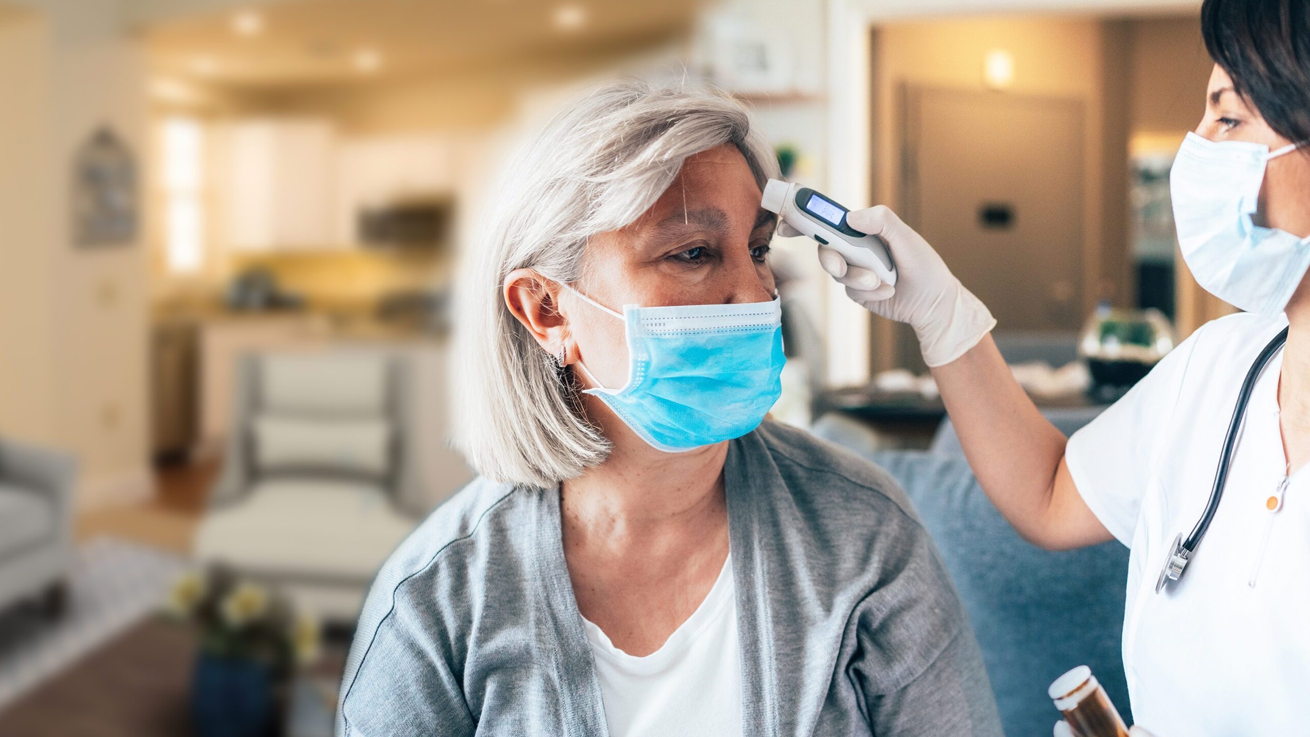 woman in mask getting her temperature read